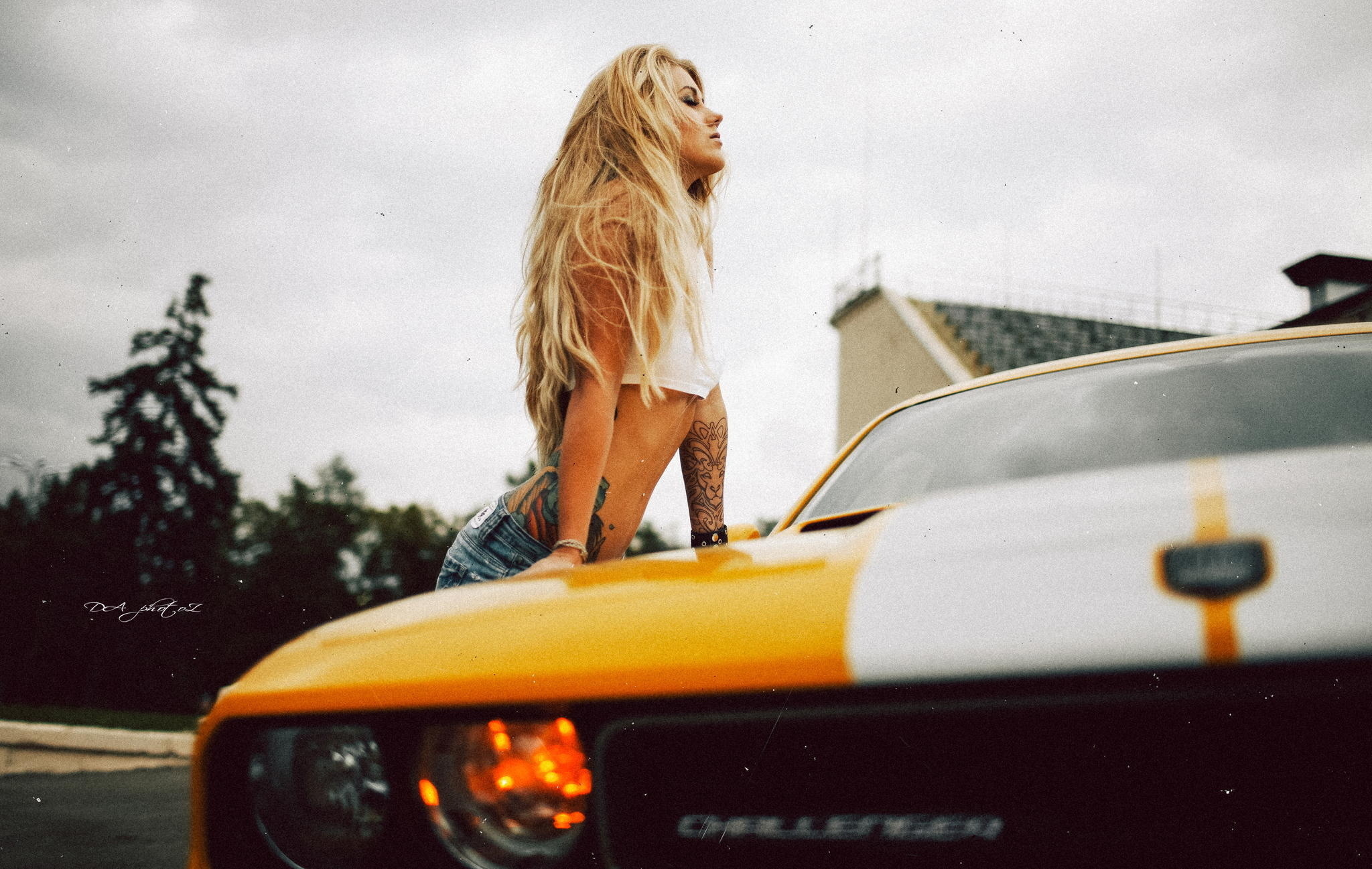 Возле желтого авто посреди дороги в эротической одежде блонда