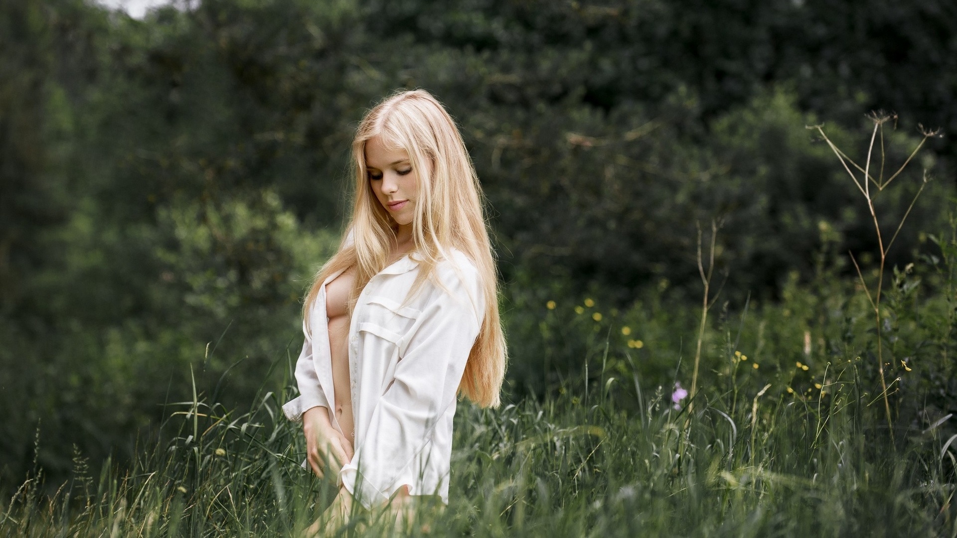 Дева с красивыми глазами в белых чулочках сидит на траве
