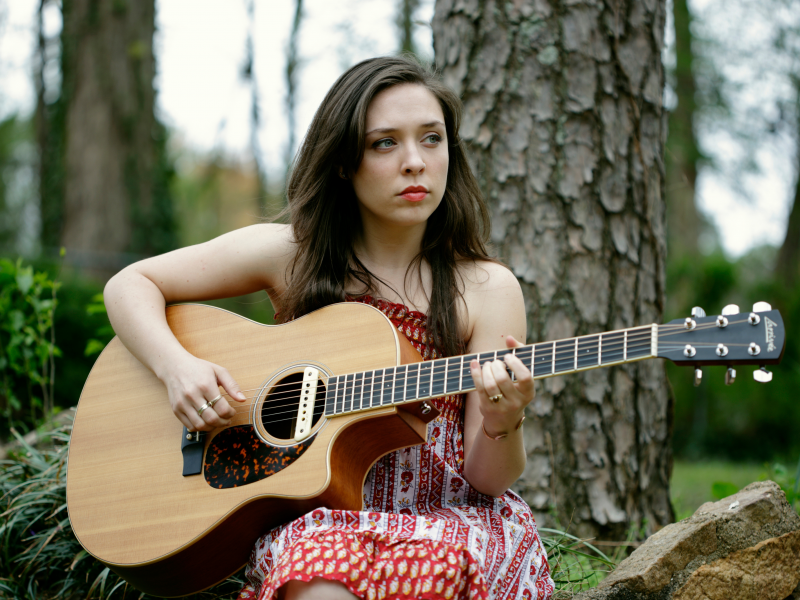 Красивая девушка красиво поет под гитару