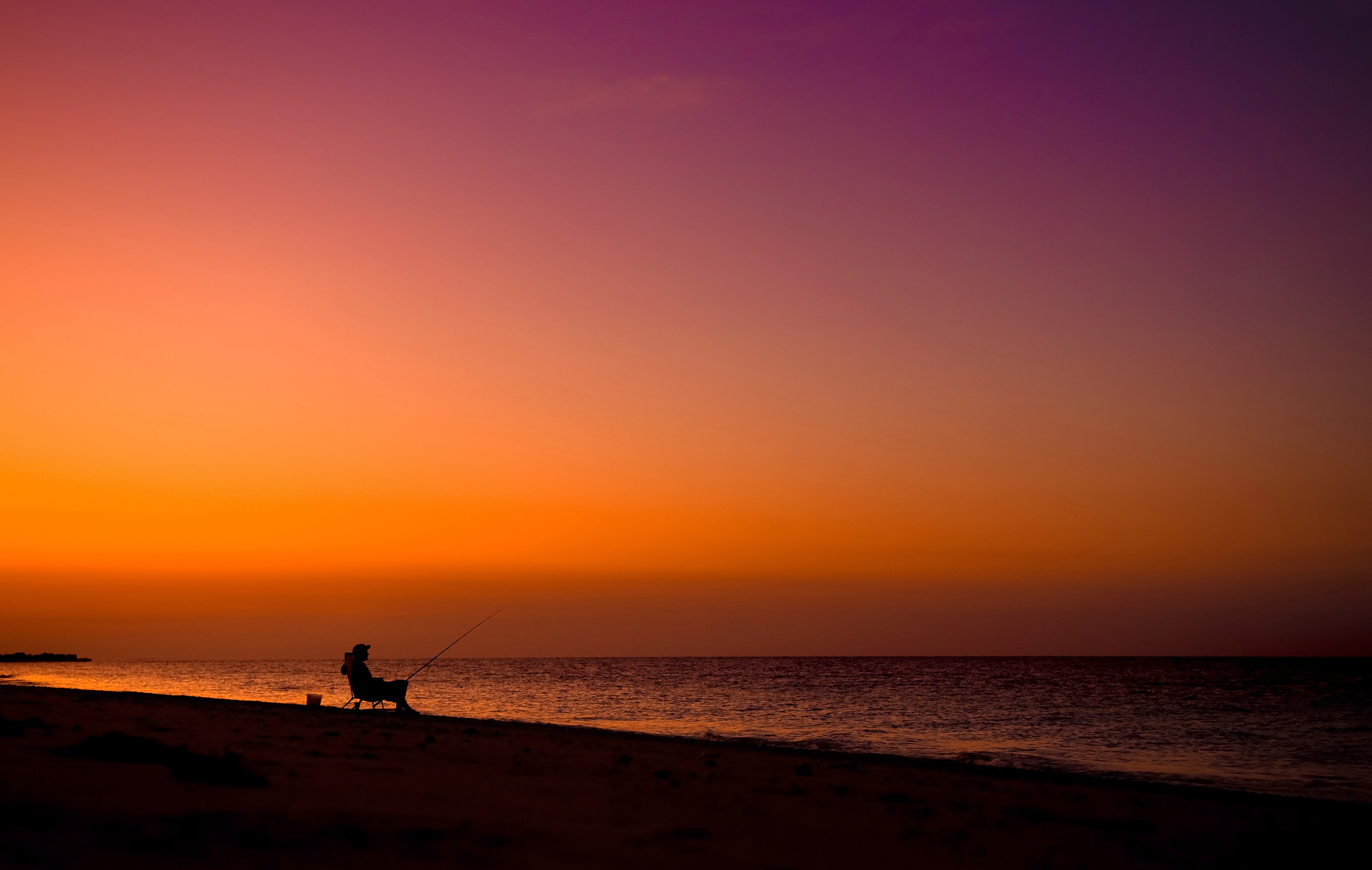 Рыбак на берегу в закате
