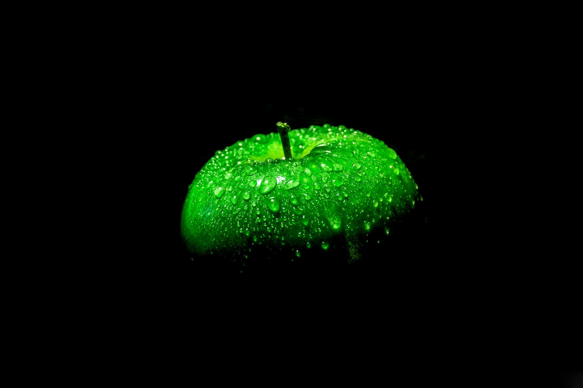 Зеленое яблоко на черном фоне