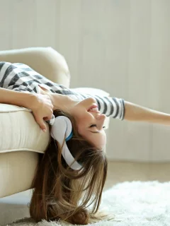 девушка, красивая, лежит на диване, в наушниках