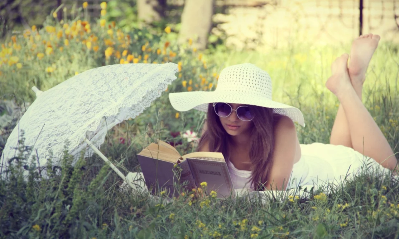 девушка, красивая, лежит на траве, читает книгу
