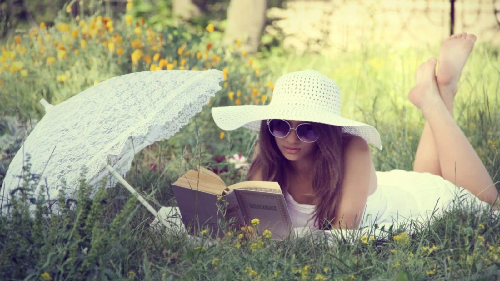 девушка, красивая, лежит на траве, читает книгу
