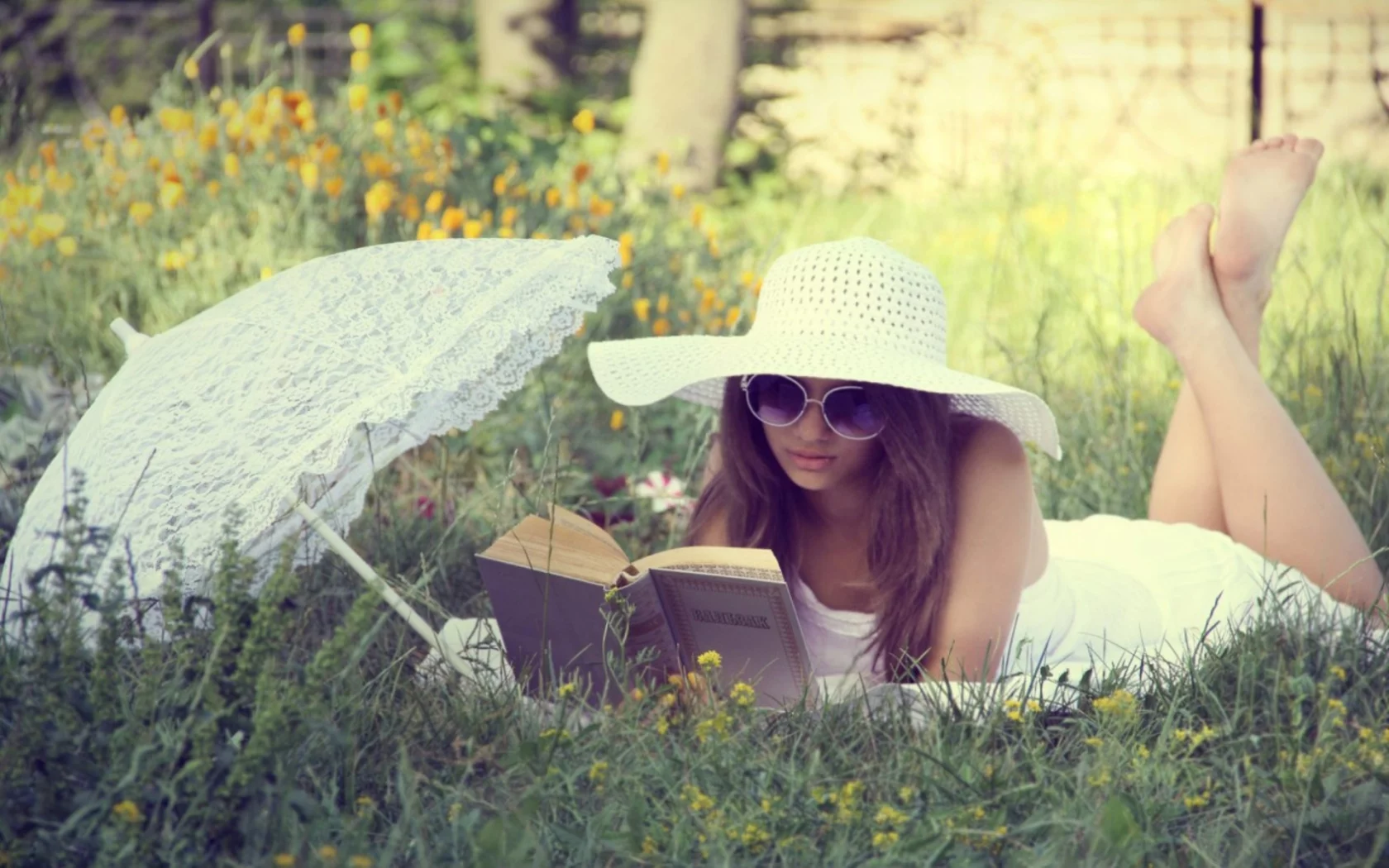 девушка, красивая, лежит на траве, читает книгу